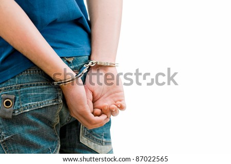Young man in handcuffs. Rear view