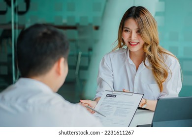 Young man handing resume to employer for job interview to review job application The concept shows the company's ability to agree on job positions, employees. - Shutterstock ID 2231611267