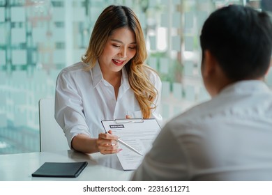 Young man handing resume to employer for job interview to review job application The concept shows the company's ability to agree on job positions, employees. - Shutterstock ID 2231611271
