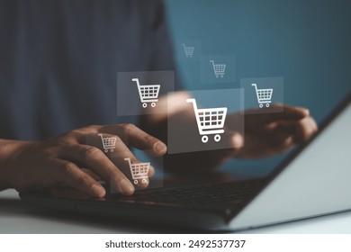 Young man hands typing on keyboard of laptop computer with shopping cart icon virtual screen. Online shopping, Online payment and e-commerce concept. Business financial technology.