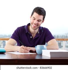 Young Man Happily Writing A Letter By Hand