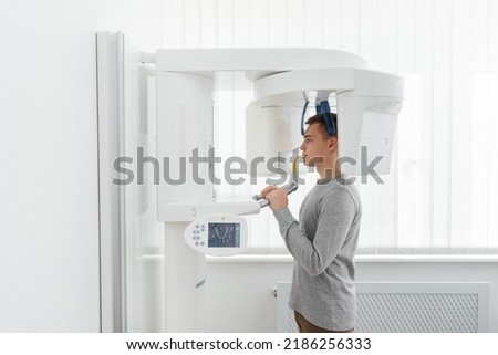 Similar – Image, Stock Photo Young man having x-ray shot of broken hand in x ray room in modern clinic. Patient wearing in protect lead apron