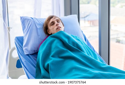 Young Man Has Fever Chills Patient Lies On Bed Of Her Shakes In The Room Hospital Background.