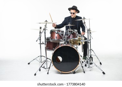 Young man in hat and sunglasses playing drums isolated on white background - Powered by Shutterstock