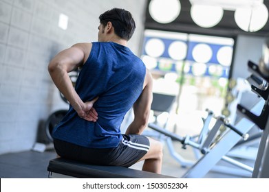 Young man having back pain after workout at the gym. - Powered by Shutterstock