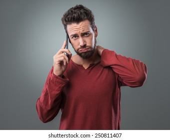 Young Man Having A Boring Phone Call Snorting And Frowning