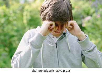 Young Man Having Eye Pain And Rubbing His Eyes