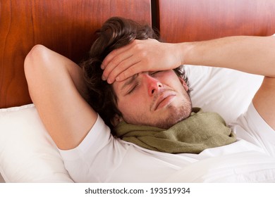 Young Man Having A Flu Lying In Bed