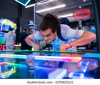 A young man is having fun at arcade entertainment center. Amusement arcade concept.