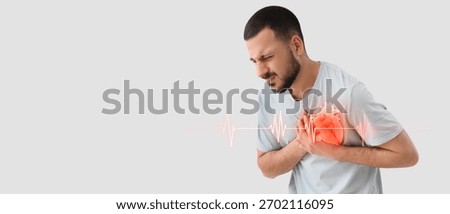 Young man having heart attack on light background with space for text