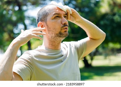 Young Man Having Hot Flash And Sweating In A Warm Summer Day
