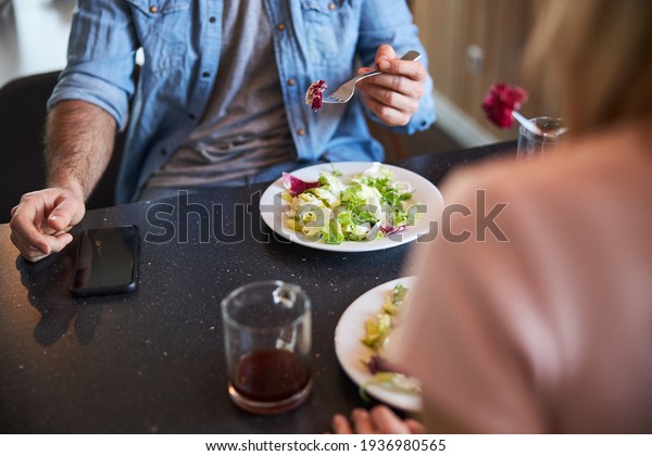 Young man having lunch\
with lady at home