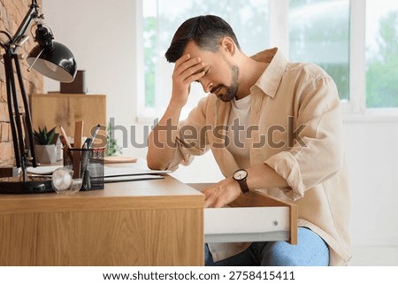 Young man having panic attack in office