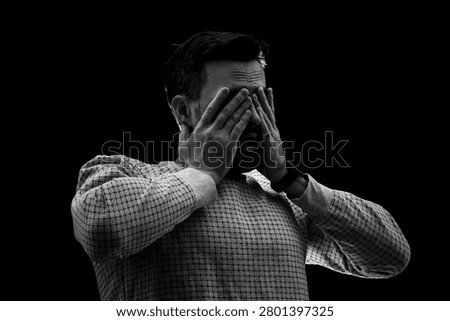 Young man having panic attack on black background, closeup