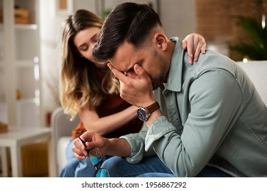 Young man having a problem. Girlfriend comforting her sad boyfriend.