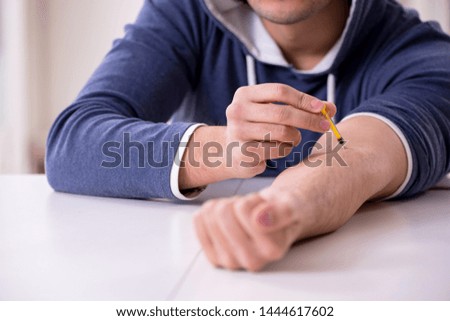 Young man having problems with narcotics at home 