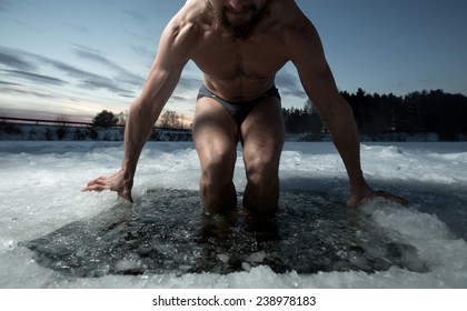 Young man having recreational swim in the ice hole