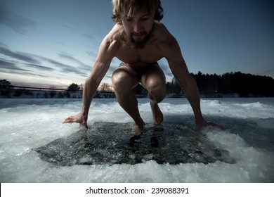 Young man having recreational swim in the ice hole