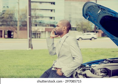 Young Man Having Trouble With His Broken Car Calling For Help On Cell Phone Isolated On City Road Outside Background