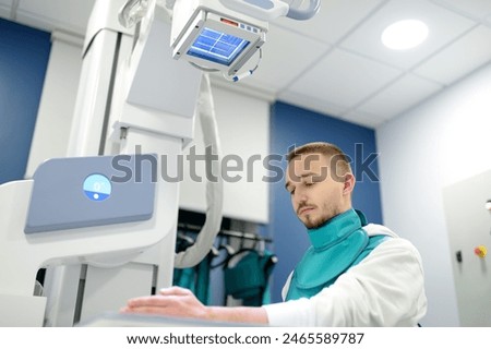 Similar – Image, Stock Photo Young man having x-ray shot of broken hand in x ray room in modern clinic. Patient wearing in protect lead apron
