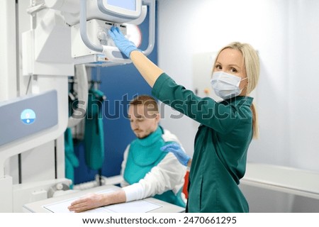 Similar – Image, Stock Photo Young man having x-ray shot of broken hand in x ray room in modern clinic. Patient wearing in protect lead apron