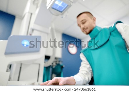 Similar – Image, Stock Photo Young man having x-ray shot of broken hand in x ray room in modern clinic. Patient wearing in protect lead apron