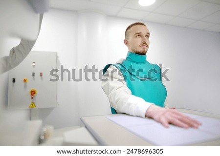 Similar – Image, Stock Photo Young man having x-ray shot of broken hand in x ray room in modern clinic. Patient wearing in protect lead apron