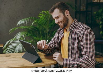 Young man he wear shirt graphic designer hold work use write draw stylus pc pen sit at table in coffee shop cafe relax rest in restaurant in free time indoors. Freelance mobile office business concept - Powered by Shutterstock