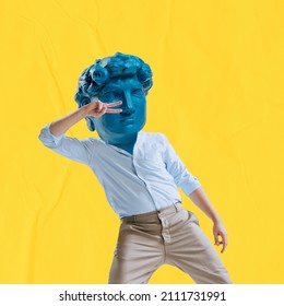 Young Man Headed By Blue Statue Head Dancing Isolated On Yellow Background. Contemporary Colorful And Conceptual Bright Art Collage. Concept Of Art, Fashion, Music, Dance, Comparison Of Eras