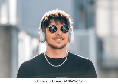 young man with headphones on the street wearing sunglasses - Powered by Shutterstock