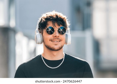 young man with headphones on the street wearing sunglasses - Powered by Shutterstock