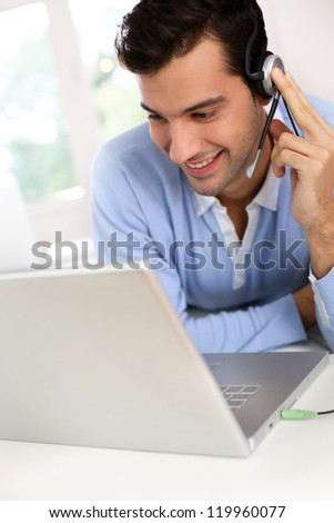 Young man with headset chating through webcamera