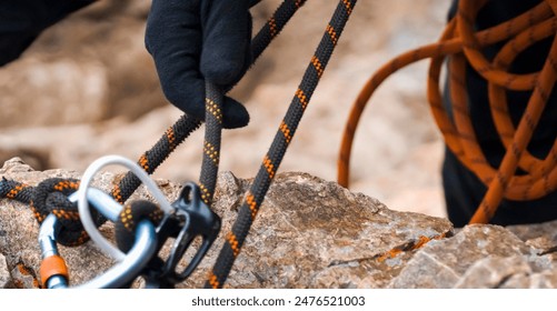 A young man in a helmet and with climbing equipment descends from the top of the mountain on a rope, the climber rappels with aperture-style self-braking belay in the snowy mountains. - Powered by Shutterstock