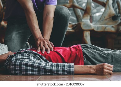 young man is helping his unconscious friend and stop breathing on the floor with CPR. Because the young man had trained to help patients with sudden cardiac arrest or CPR Cardiopulmonary Resuscitation