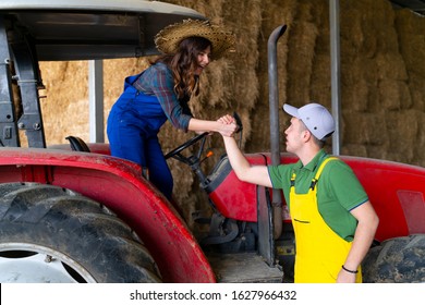 Young man helping the lady get off the tractor - Powered by Shutterstock