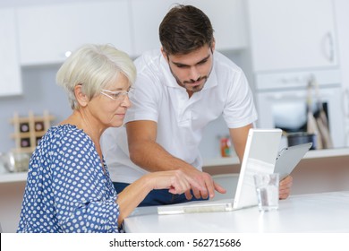 Young Man Helping Lady With Her Computer