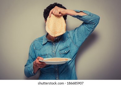 Young Man Is Hiding His Face Behind A Pancake