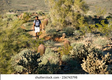 Young Man Hiking Outdoors On A Trail At Phoenix Sonoran Preserve In Phoenix, Arizona.