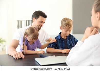 Young man and his children meeting with headmistress at school