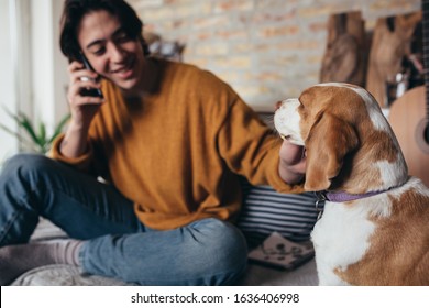 young man with his dog at home - Shutterstock ID 1636406998