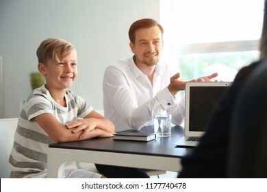 Young man and his son meeting with headmistress at school