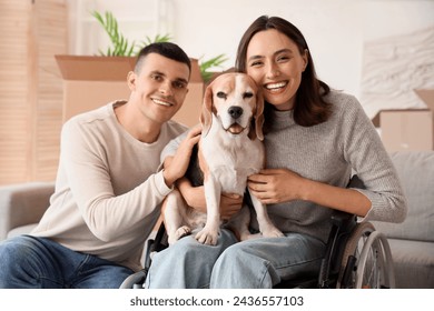 Young man and his wife in wheelchair with Beagle dog on moving day - Powered by Shutterstock