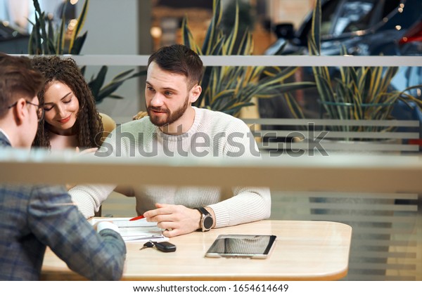 young man and his woman discussing buying\
process. manager working with clients at the cafe. meeting with\
customers. business