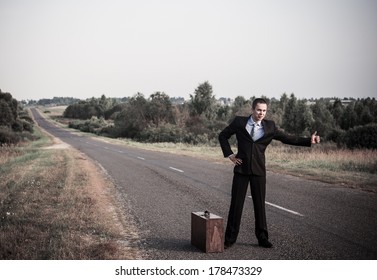 Young Man Hitchhiking On A Road