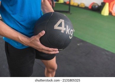 A Young Man Holding A 4 Kg Medicine Ball. Doing Cross Training Or Other High Intensity Workout At The Gym.