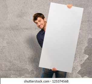 Young Man Holding Banner On Wall