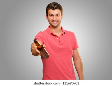 Young Man Holding A Beer Isolated On Grey Background