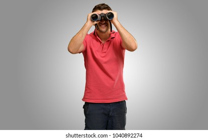 Young Man Holding Binoculars Isolated On Grey Background