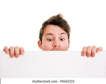 Young man holding a blank board and looking down. Isolated on white.