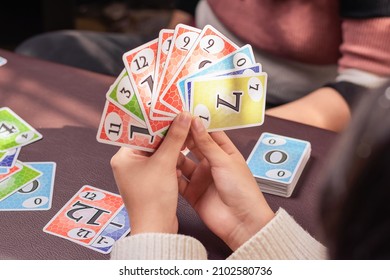 Young Man Holding Board Game Cards In The Comfort Of His Home